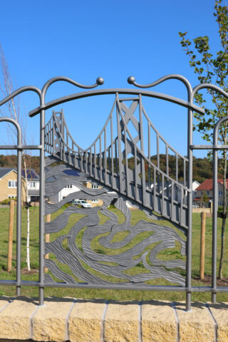 Forged and fabricated decorative panel from mild steel to depict the swirling water of the Firth of Forth and the Forth Road Bridge towering above the water.