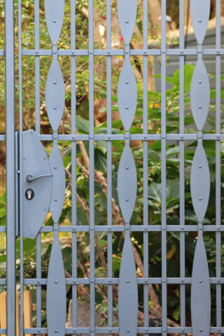 Detail showing the horizontal and vertical bars of the gate riveted together and the lock box.