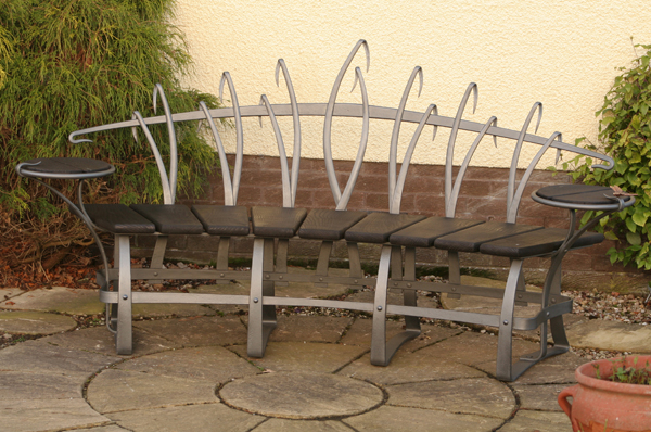 Curved patio bench incorporating tables either end.