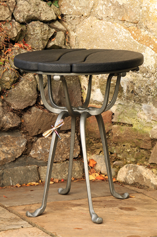 Patio table with forged stainless steel damselfly landing on the table leg. Forged mild steel, galvanised and painted Ratho Grey.